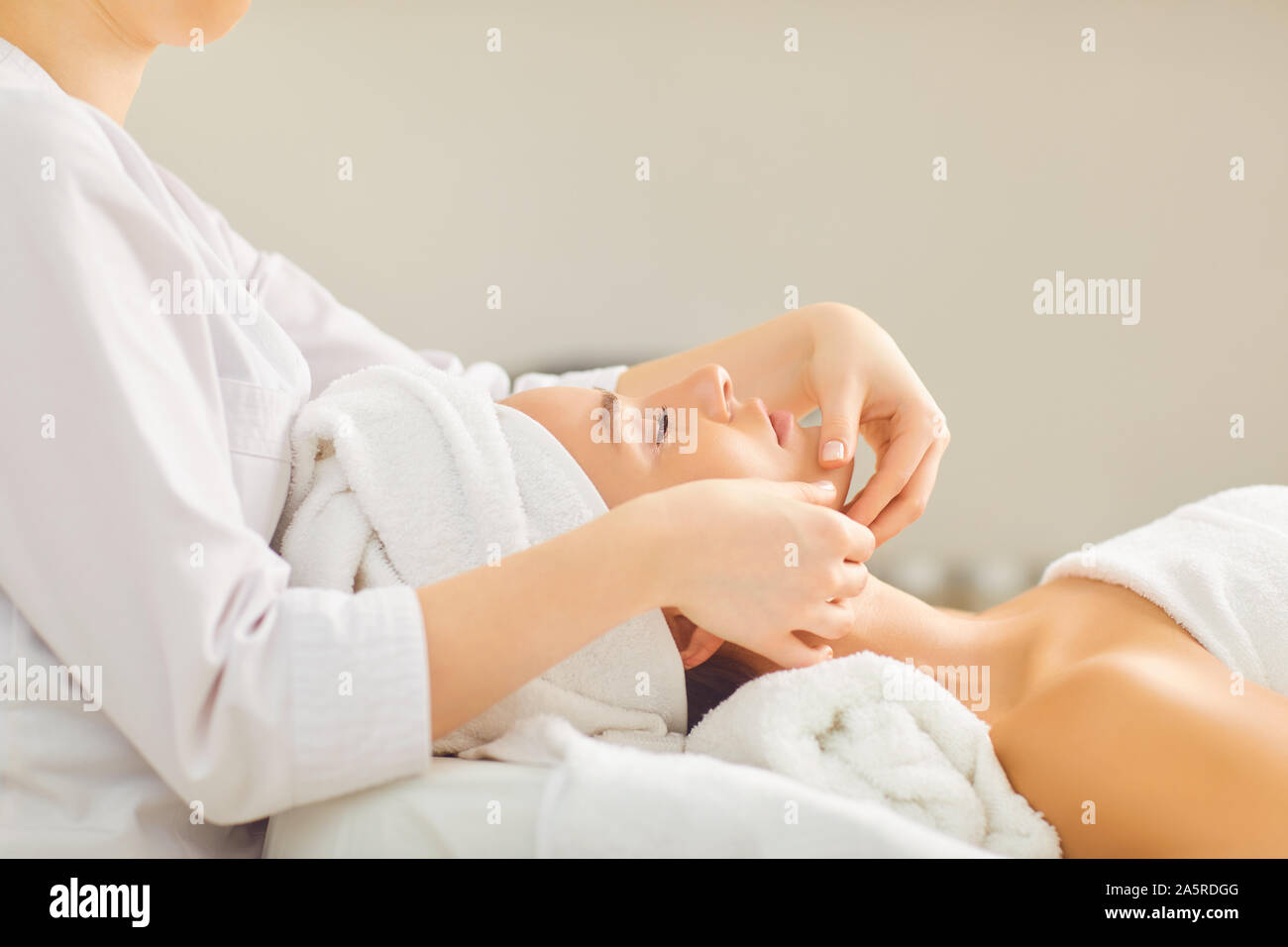 Gesichtsmassage zu einem wunderschönen Mädchen in einer Schönheitsklinik. Stockfoto