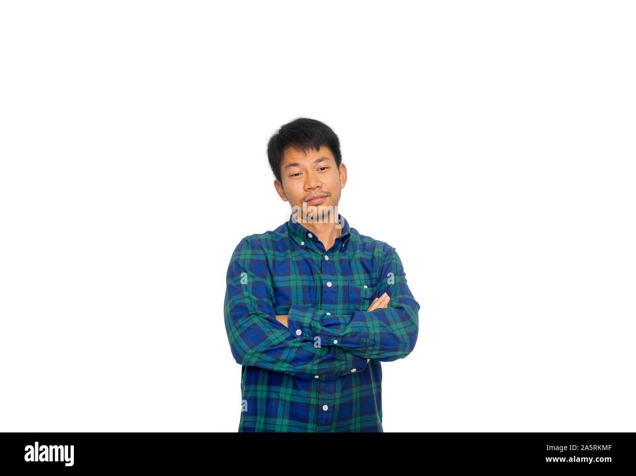 Die asiatische ungepflegte Mann in Blue Plaid Shirt kreuzt seine Arme und auf dem Boden an etwas denken. Stockfoto