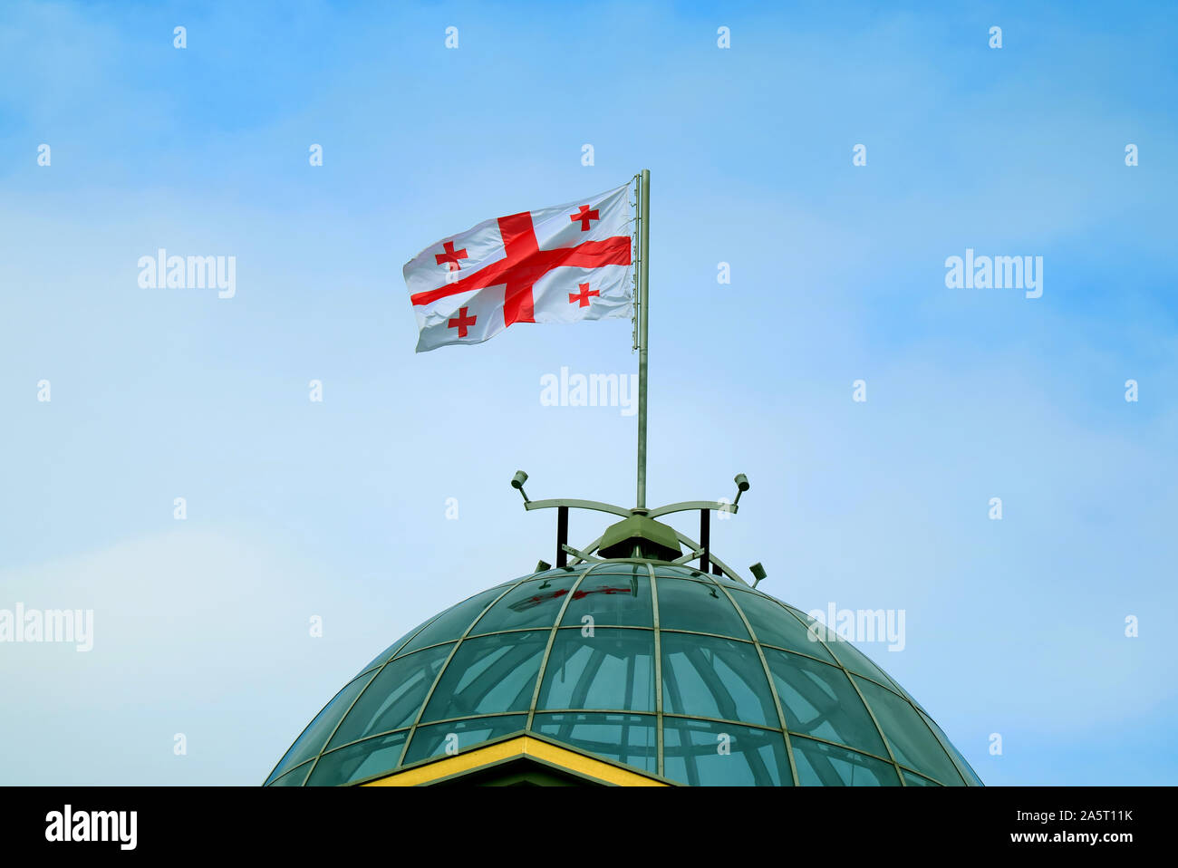 Die georgische Flagge oder die fünf Kreuze Flagge Schwenkten im blauen Himmel Stockfoto