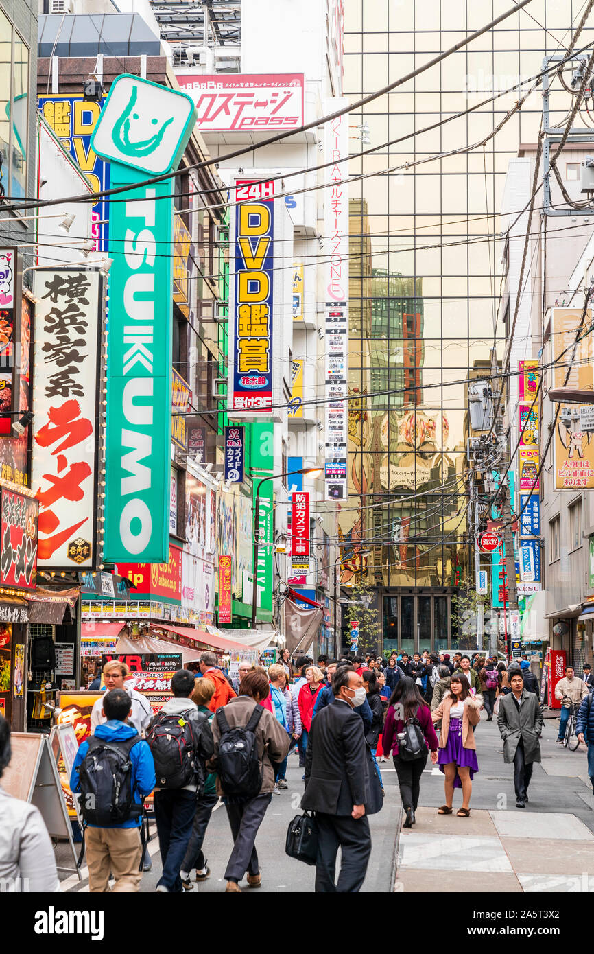 Tokio, Akihabara. Schmale Straße mit Dienstmädchen touting für Unternehmen für elektronische Spiele Maid Cafés, Geschäften und Restaurants. Besetzt mit Menschen, tagsüber. Stockfoto