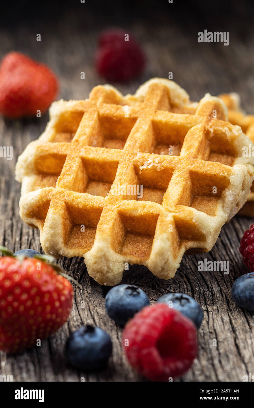 Waffeln mit Heidelbeeren und Himbeeren auf alten Holztisch. Stockfoto