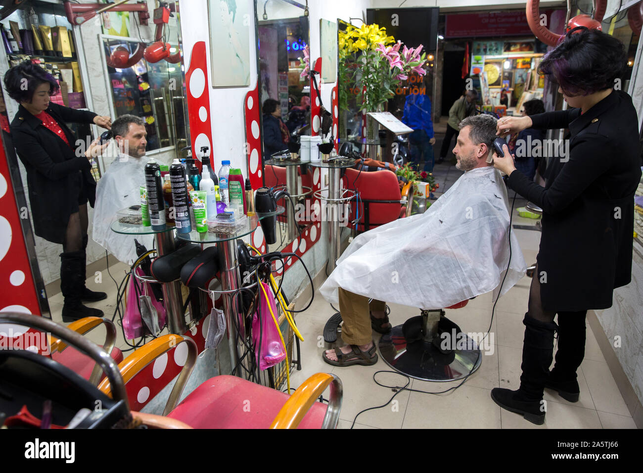 Ein Mann erhält einen Haarschnitt in einem vietnamesischen Barbershop in Hanoi, Vietnam. Stockfoto