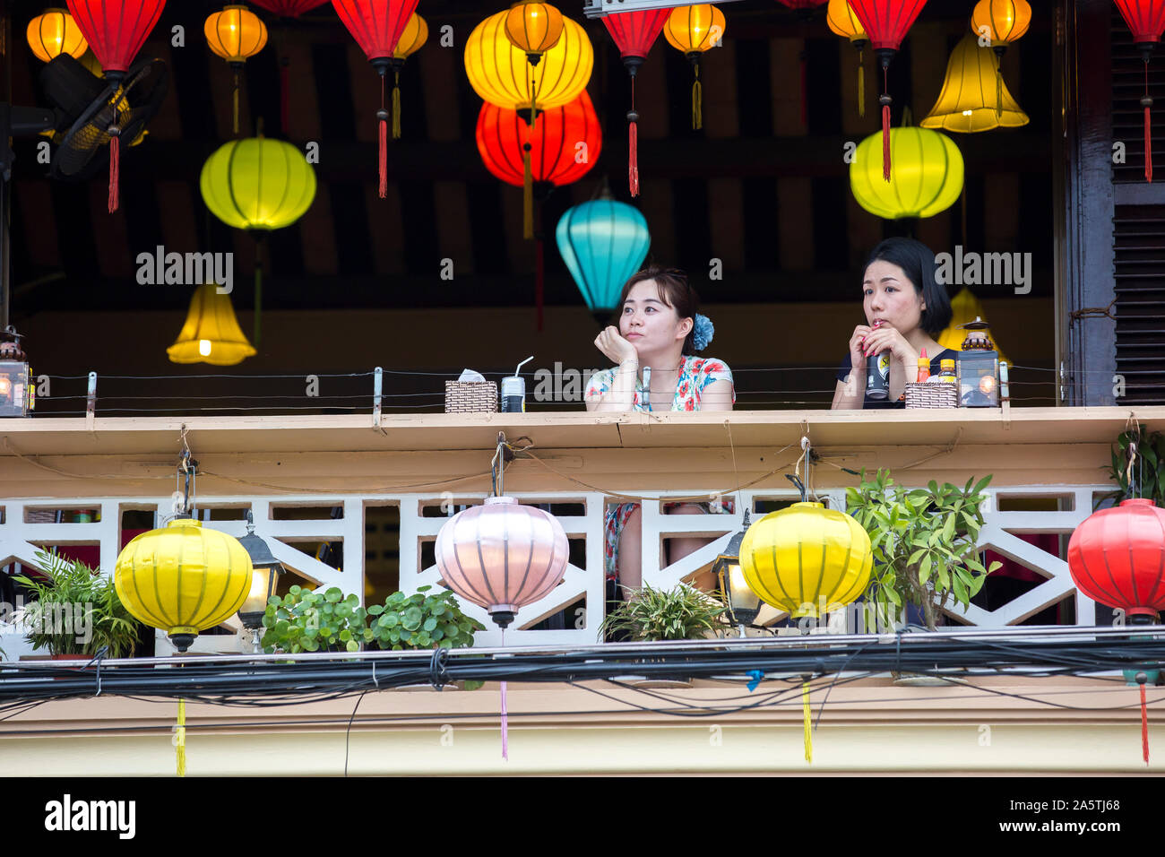 Zwei Frauen genießen Getränke von Laternen in Hoi An, Vietnam umgeben. Stockfoto