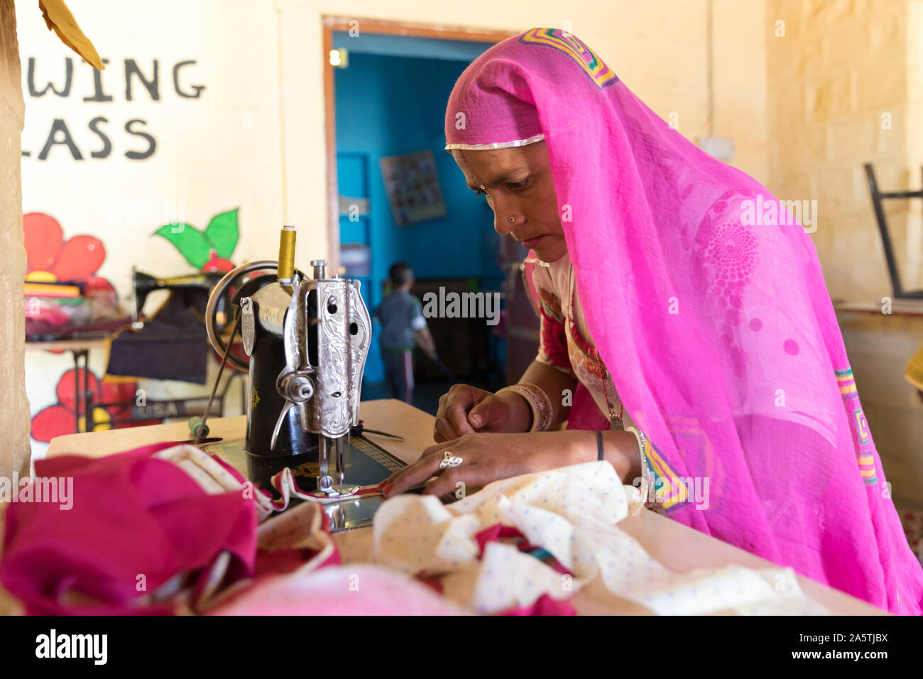 Eine indische Frau näht mit einem alten Singer-Nähmaschine. Stockfoto