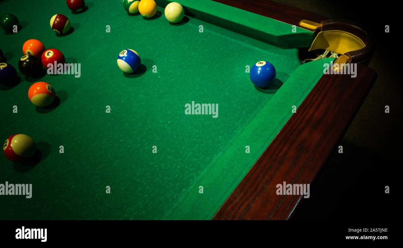 Paar bunte Nummern auf den Kugeln am grünen Tisch, in der Nähe der Ecke und Ball Tasche.. Horizontale Hintergrund mit Ausrüstung für Americal Billardqueue sport gam Stockfoto