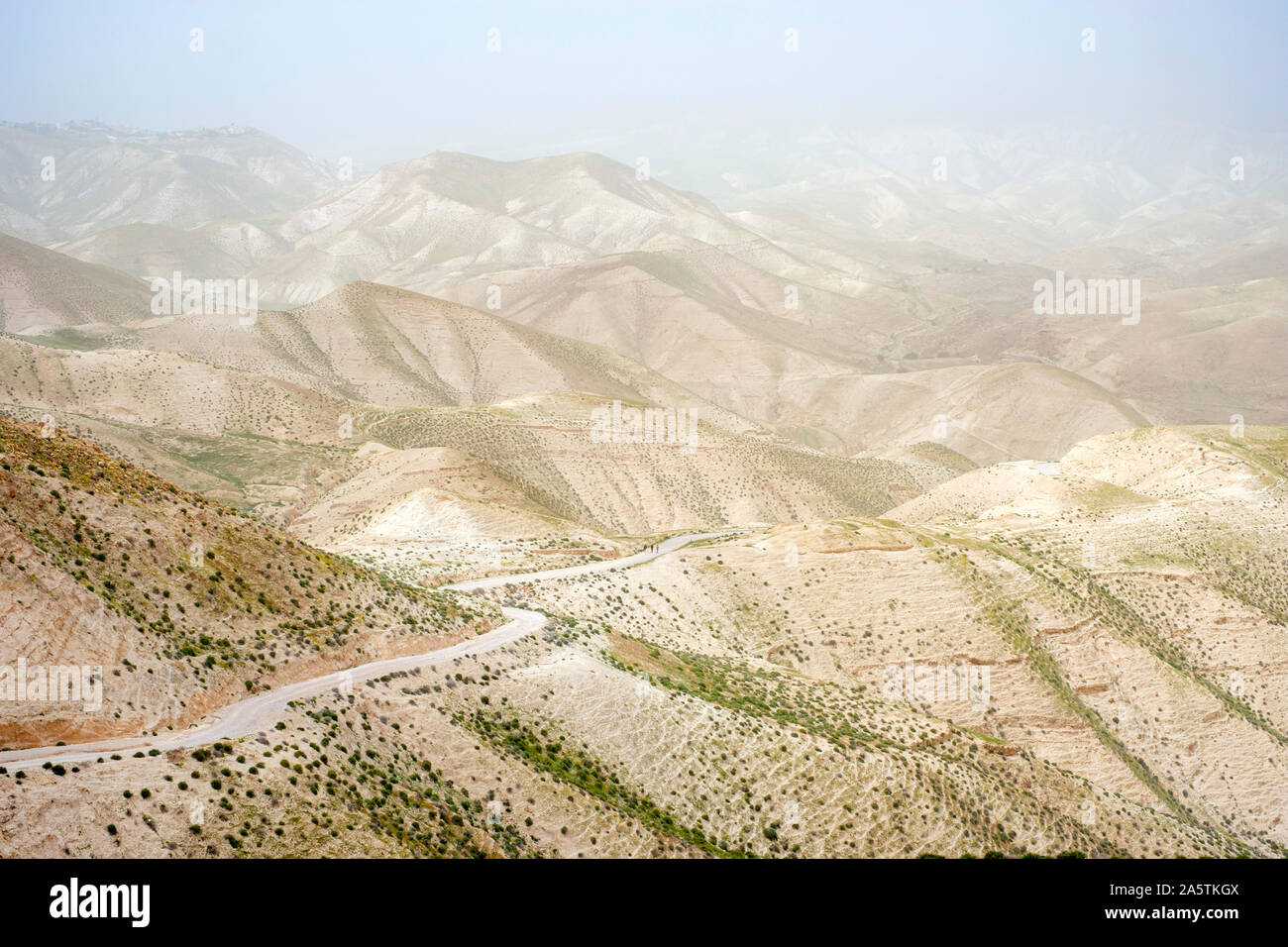 Wanderer zu Fuß durch die judäische Wüste Landschaft während Sandsturm, Wadi Quelt, Prat River Gorge, Jericho Governatorat, West Bank, Palästina. Stockfoto