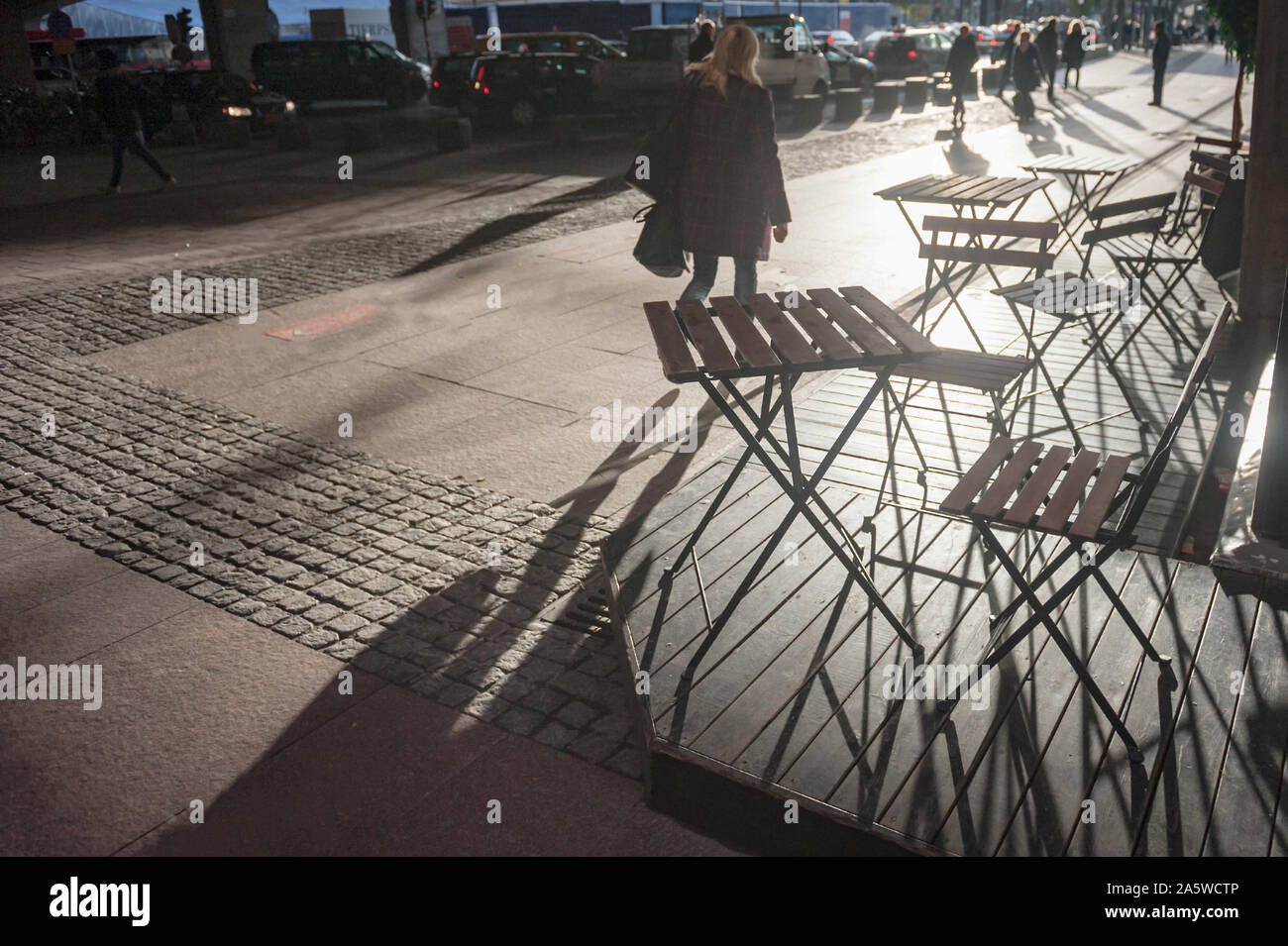 Schatten der Völker und Stühlen wie die grafische Figuren auf dem Boden in den frühen Morgen, Stockholm, Schweden. Stockfoto