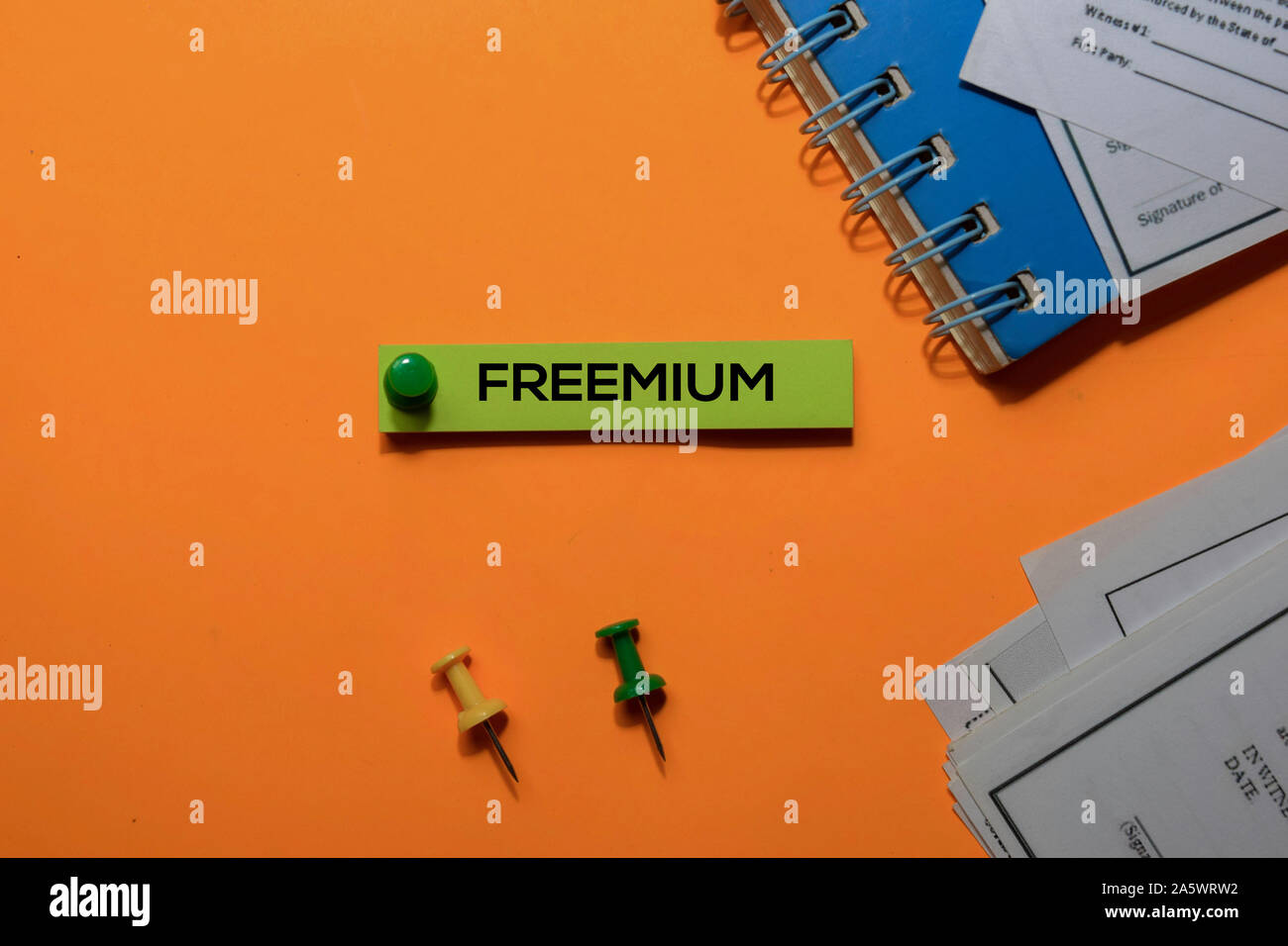Freemium auf Haftnotizen schreiben. Auf orange Tabelle Hintergrund isoliert Stockfoto