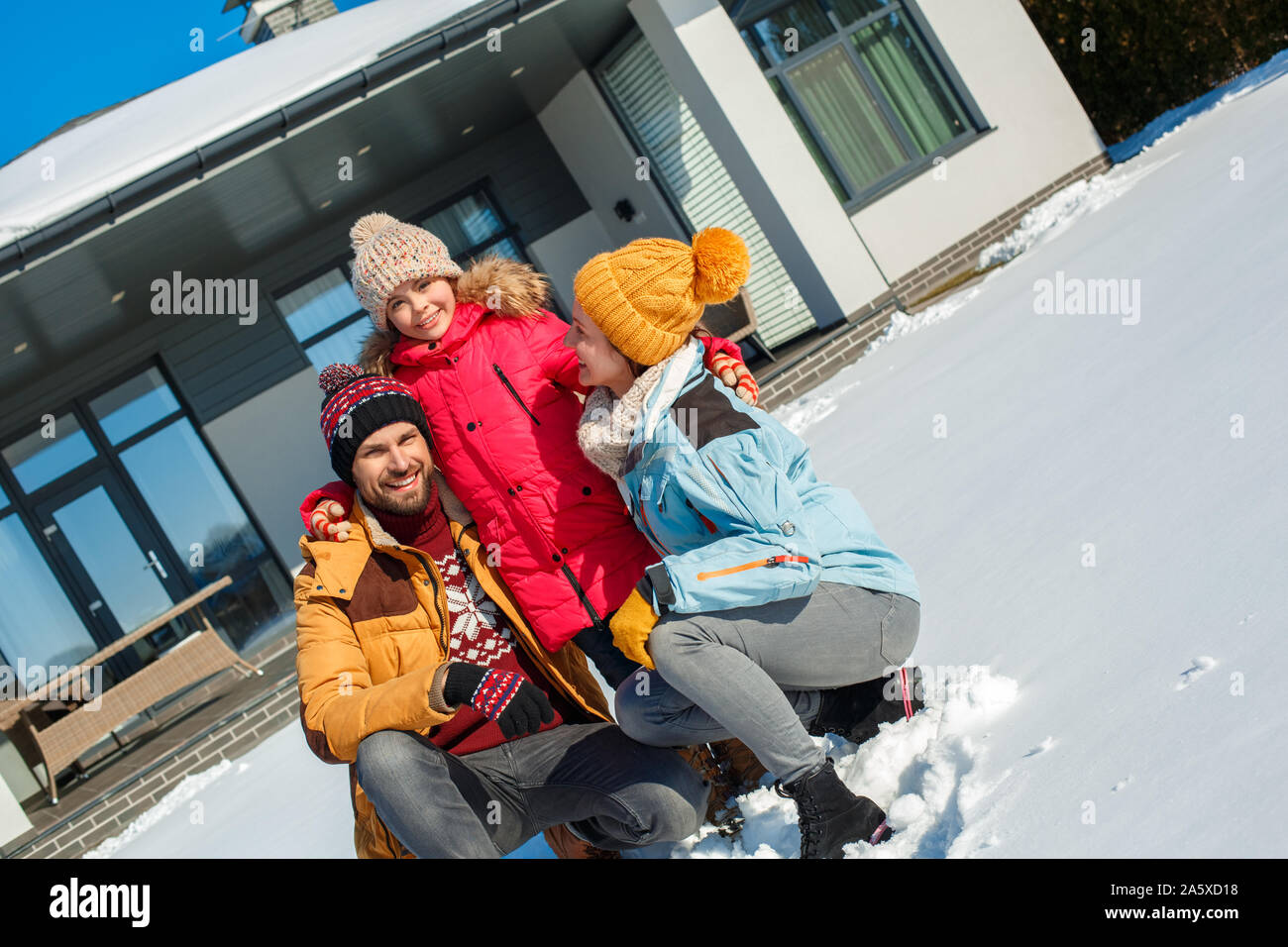 Winter Urlaub. Zeit mit der Familie zusammen im Freien in der Nähe von Haus fröhlich lächelnd umarmen Stockfoto