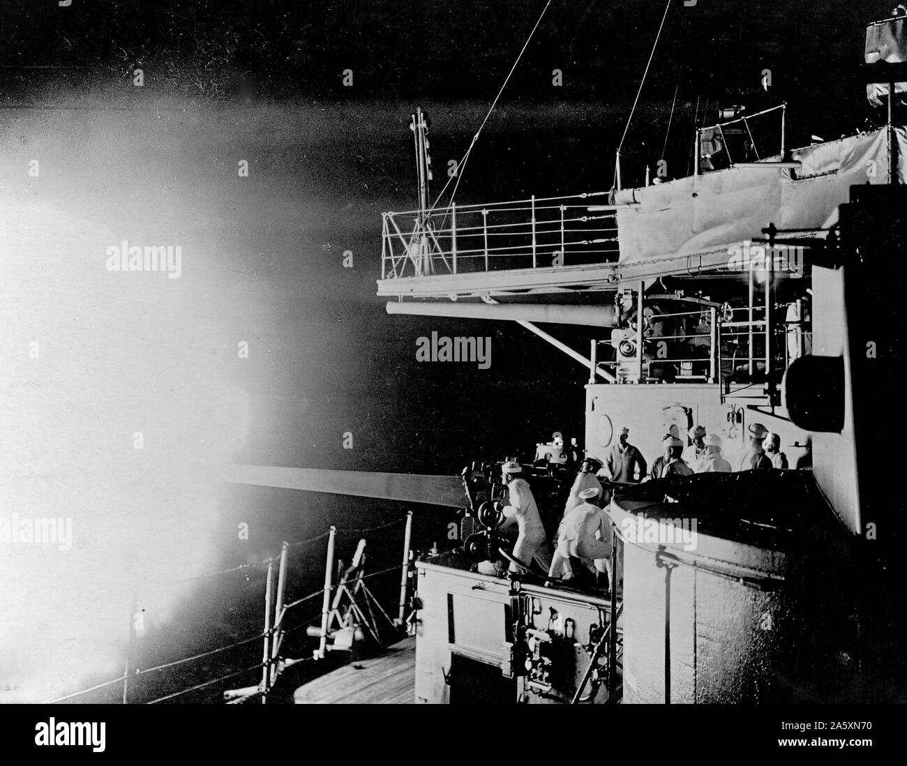 Nacht brennen von Deck eines Vereinigten Staaten Schlachtschiff. Die Crew, einer der grossen Gewehren, welcher Befehl das Meer, Ziel in der Dunkelheit. Us Navy, den Hafen von New York, New York, U.S.A. Ca. 1918 Stockfoto