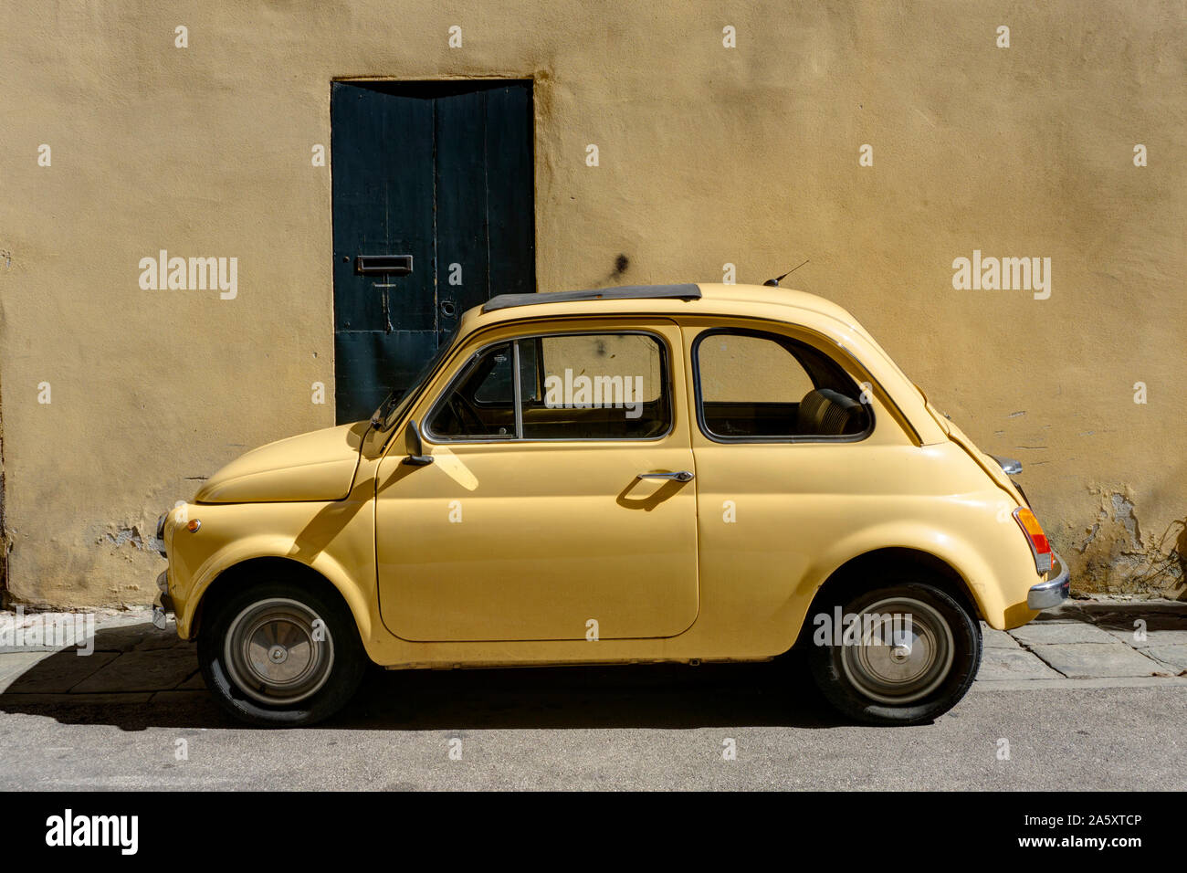 Gelbe Fiat 500 Vor gelb getünchten Wand Lucca Italien geparkt Stockfoto