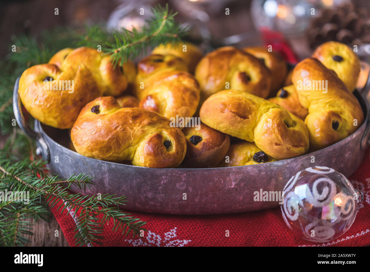 Ein Fach des frisch gebackenen hausgemachte Schwedische traditionelle Safran Brötchen, auch als lussekatter oder lussebullar bekannt. Die gelbe Brötchen haben Rosinen und sind Shap Stockfoto