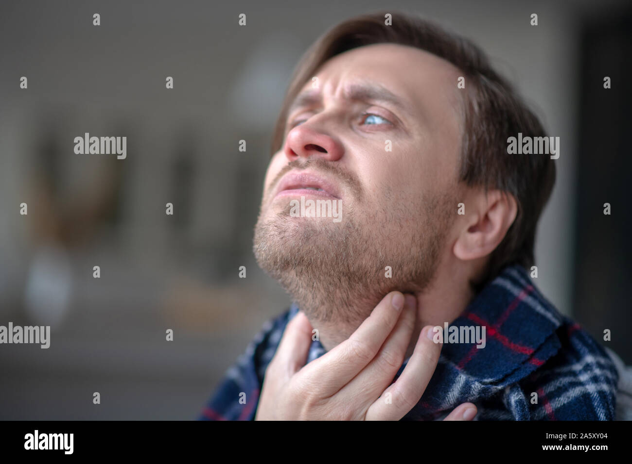 Blauäugigen Menschen unter schrecklichen Schmerzen in Hals Stockfoto