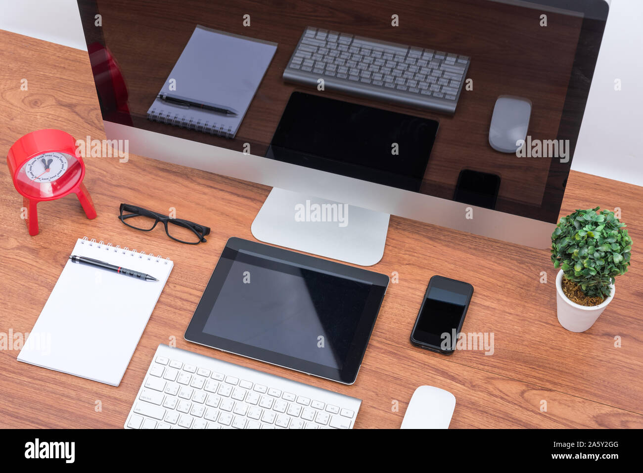 Office Monitor Computer PC, Tastatur, Mobiltelefon, Magic Mouse und Tablet auf hölzernen Schreibtisch Stockfoto