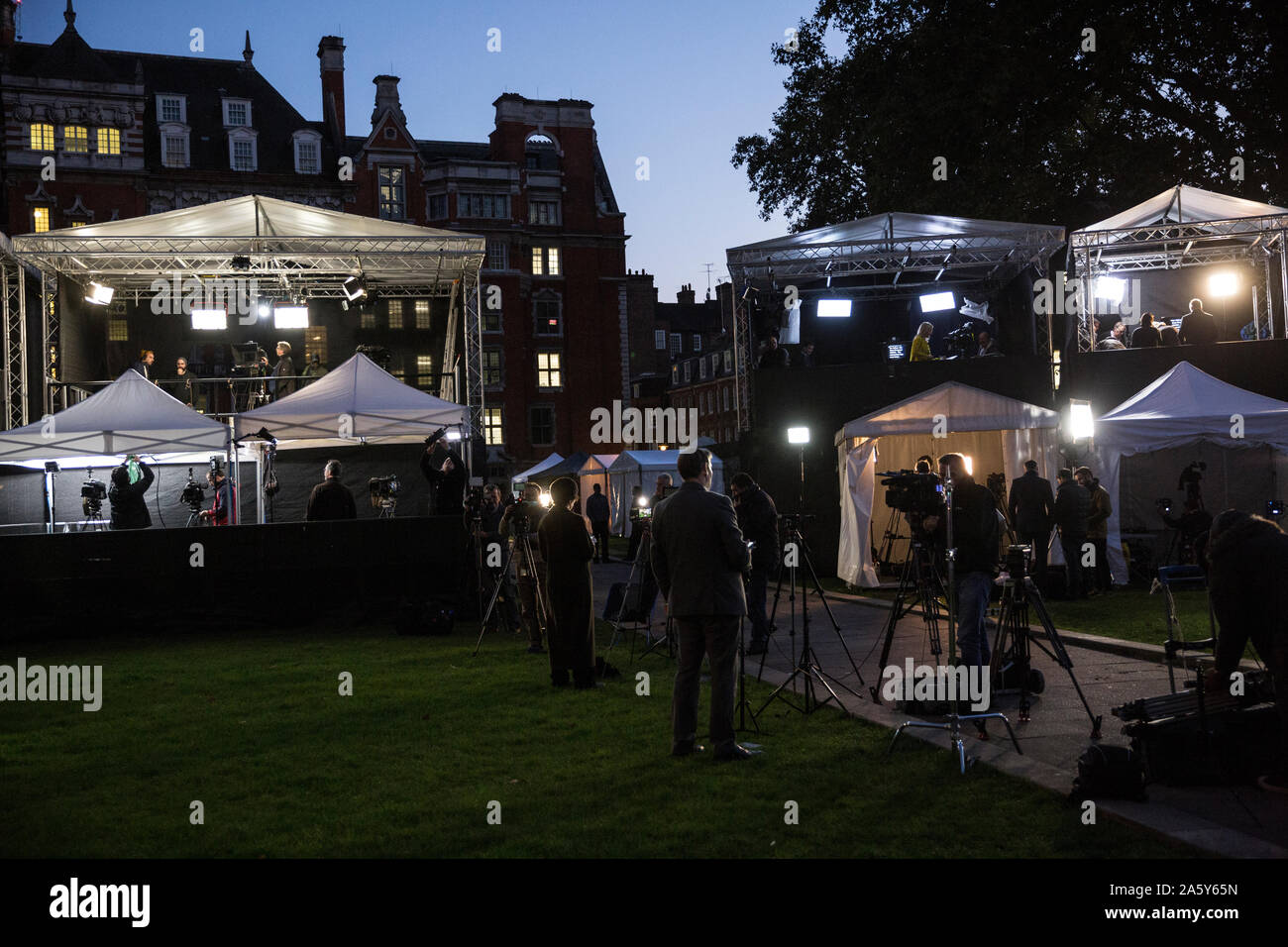 Medien- und TV-Moderatoren laufen auf das College Green mit Blick auf die Häuser des Parlaments vor dem 31. Oktober Brexit Stockfoto