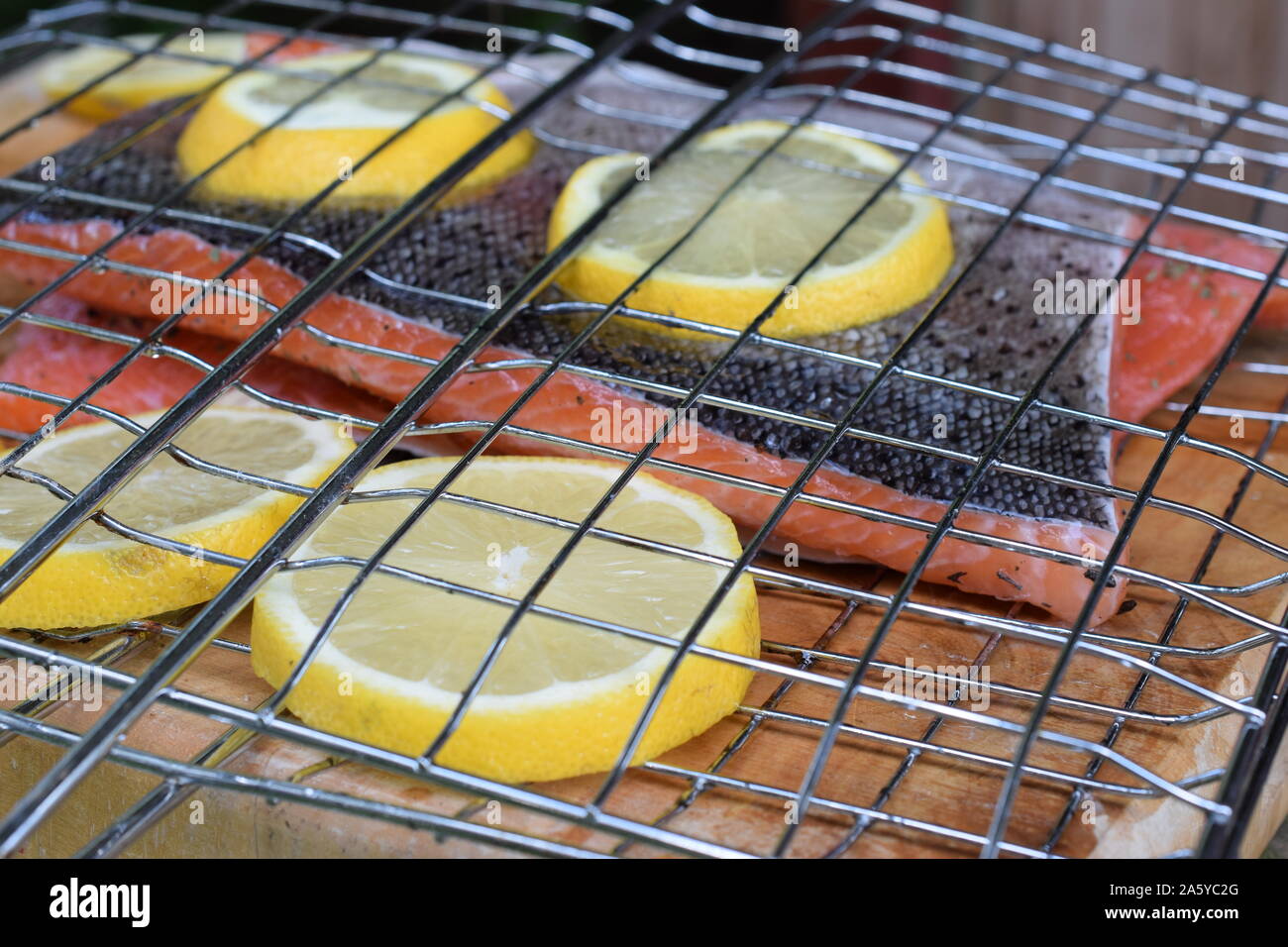 Lachsfilets mit Zitronenscheiben in Bratrost. Bereit für Grill. Stockfoto