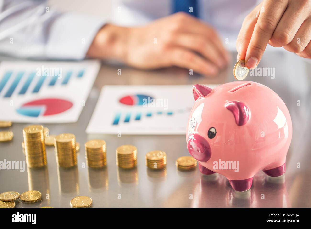Banker Buchhalter oder Versicherer Geld in ein Sparschwein. Finanzielle chart von Münzen Business Konzept Stockfoto