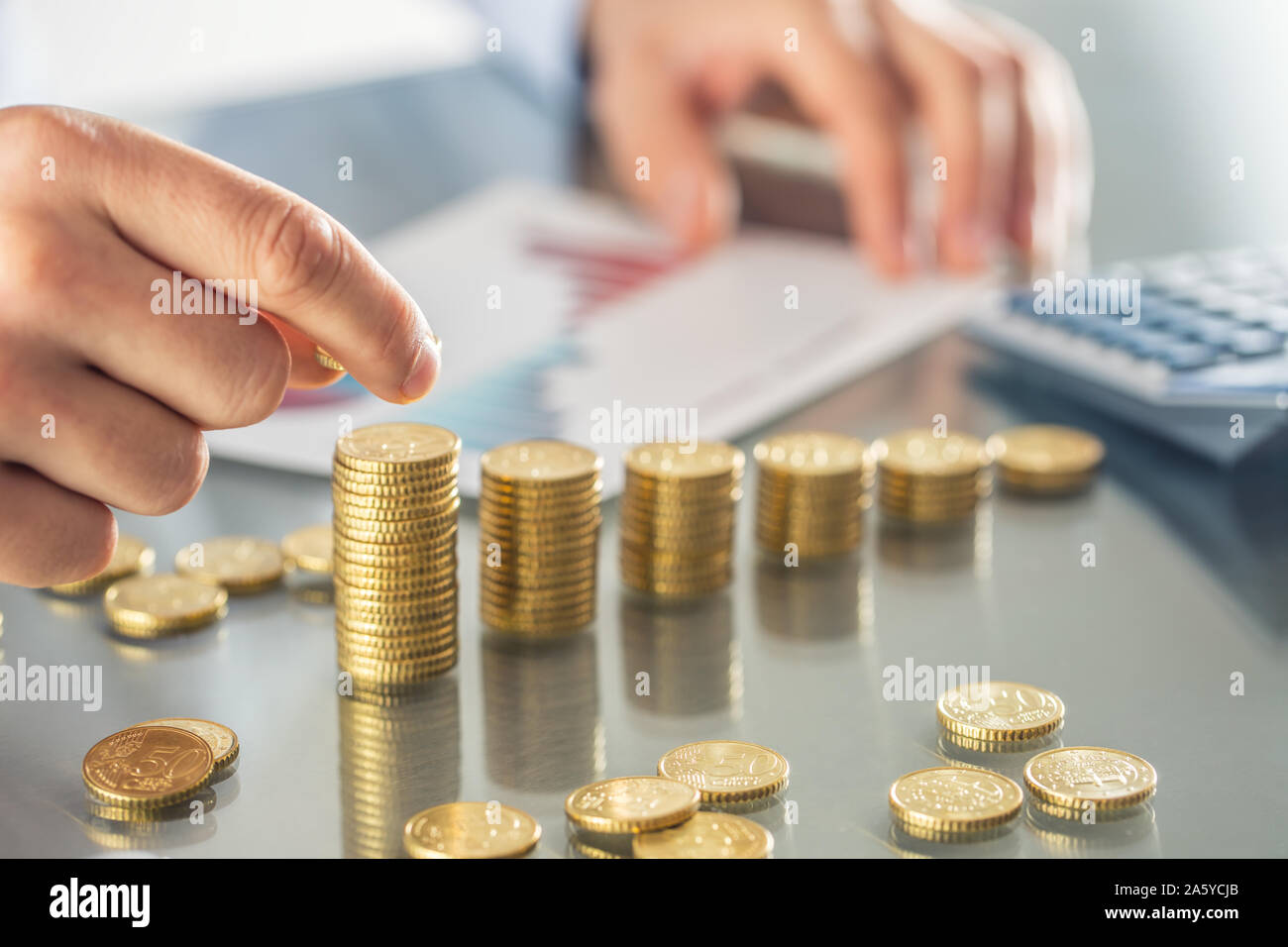 Banker Buchhalter oder Versicherer baut finanzielle Diagramm von Goldmünzen. Stockfoto