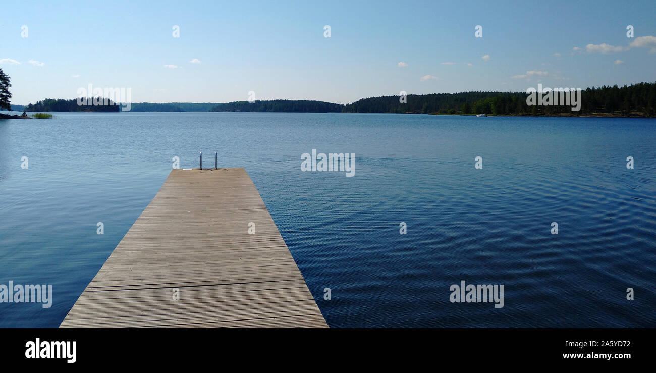 Lange hölzerne Seebrücke und schönen Saimaa-See, Finnland auf warm und windstill Sommertag. Stockfoto