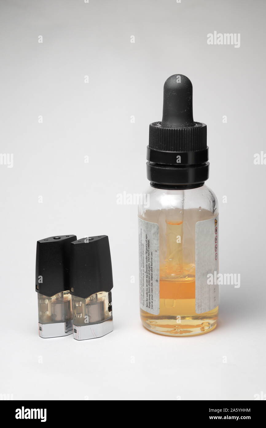 E-Saft vape nachfüllen Pods mit mit einer Flasche orange e-liquid, isoliert in der Nähe auf weißem Hintergrund Stockfoto