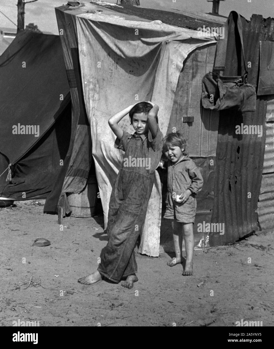 Zwei Kinder von Wanderarbeitern Obst Arbeiter aus Tennessee, vor ihrem Zuhause auf Zeit. Diese Familie von acht ist in einem Feld in der Nähe des packinghouse in Winter Haven, Florida 19370101 lagerten Stockfoto