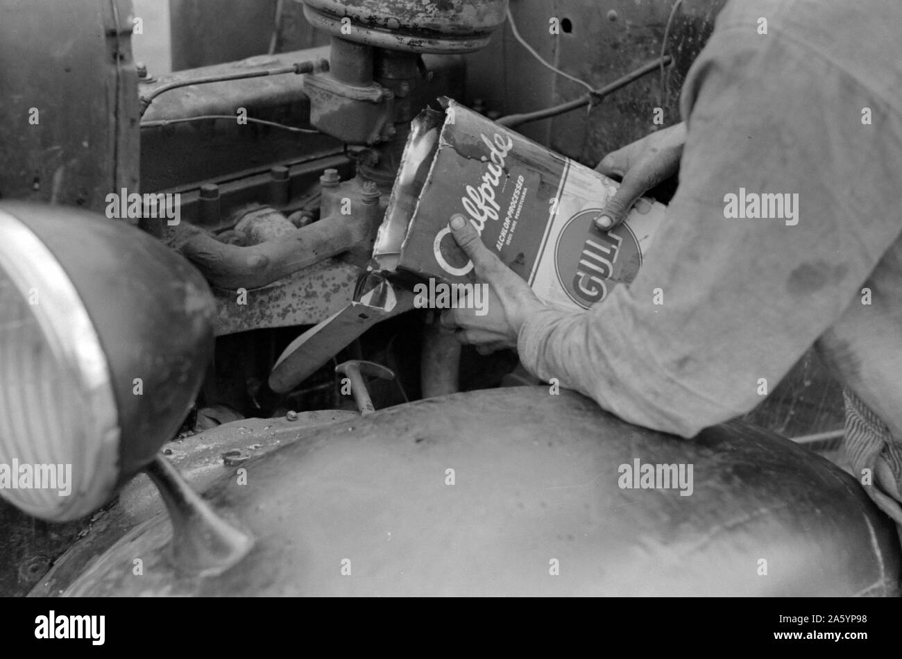 Wanderarbeitnehmer goß Öl in Motor des Automobils in der Nähe von Harlingen, Texas von Russell Lee, datiert 1903-1986, 19390101. Stockfoto