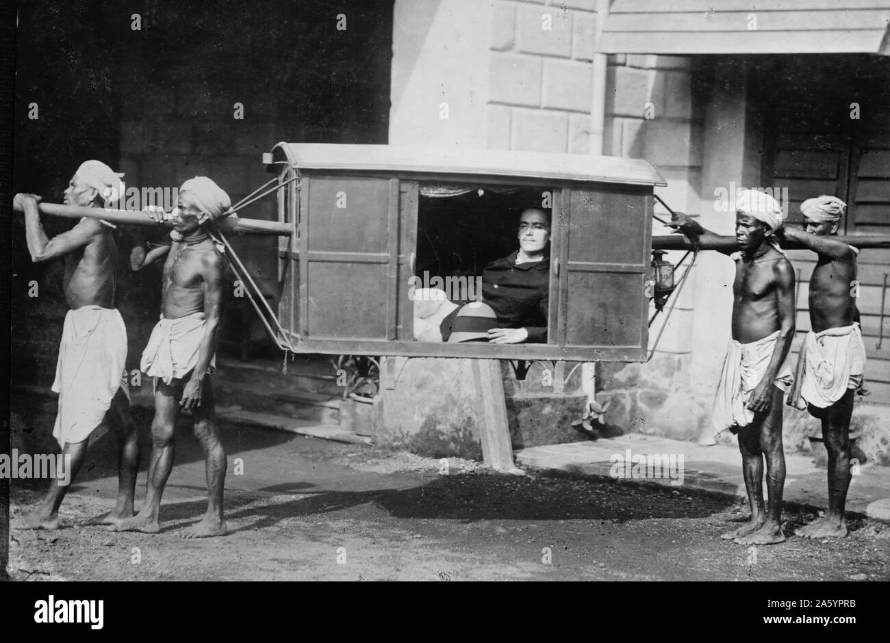Reicher englischen Kaufmann in einer Sänfte, Indien durchgeführt. 1922. Stockfoto