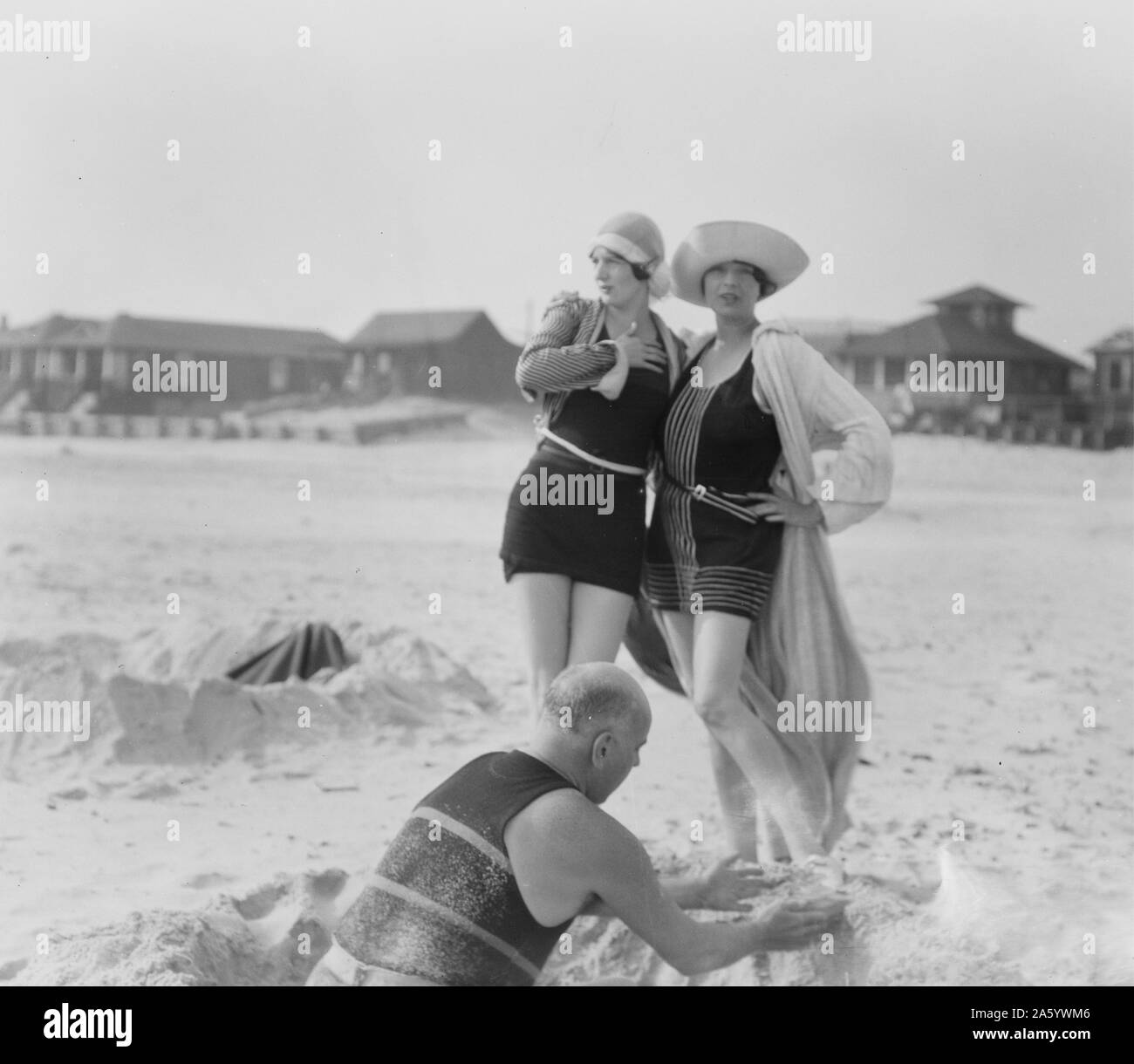 Unbekannter Mann bauen Sandburg und zwei Frauen, Long Beach, New York 1910 von Arnold Genthe 1869-1942, Fotograf Stockfoto