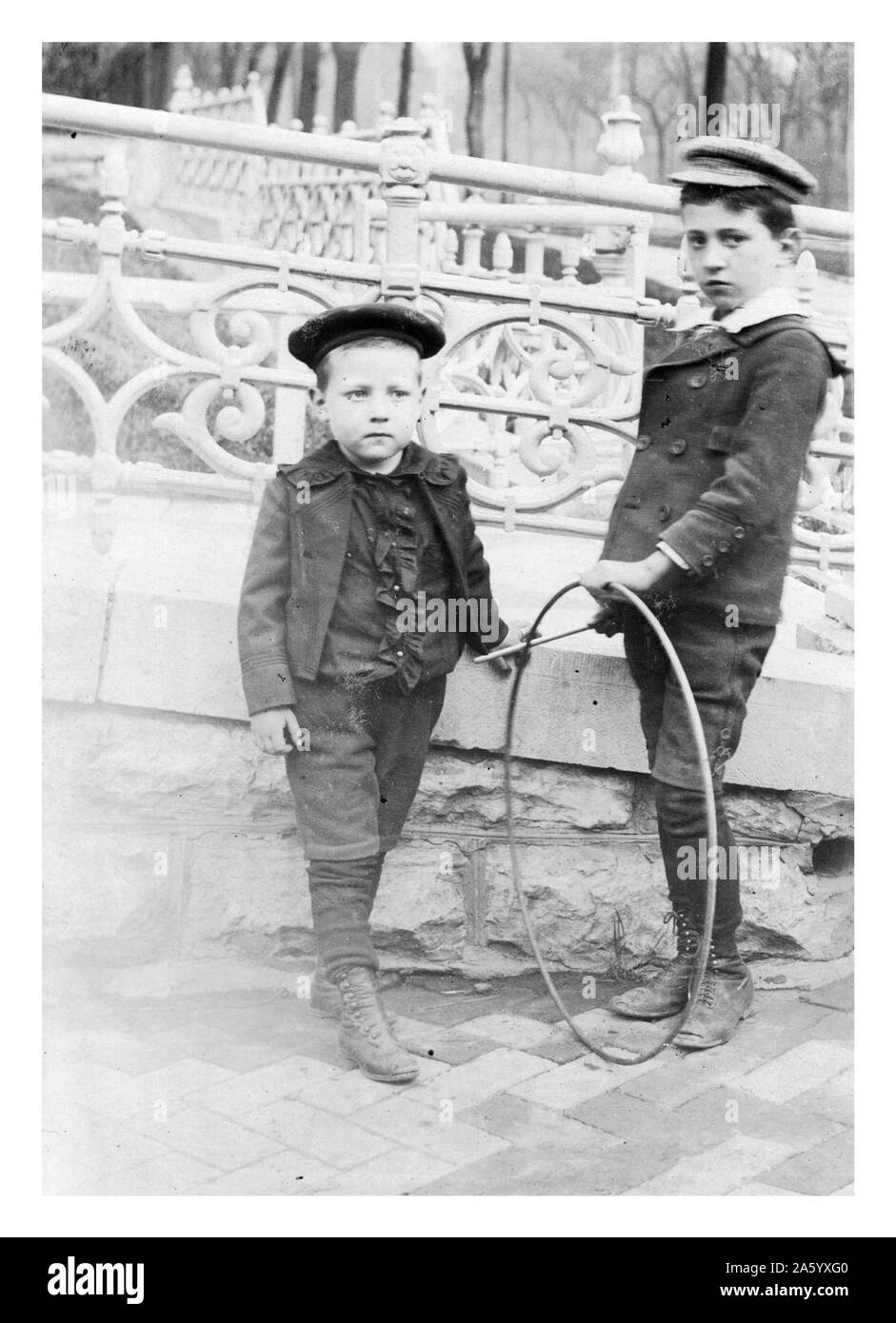 Zwei Jungs spielen mit kreisförmigen Reifen 1900 Stockfoto