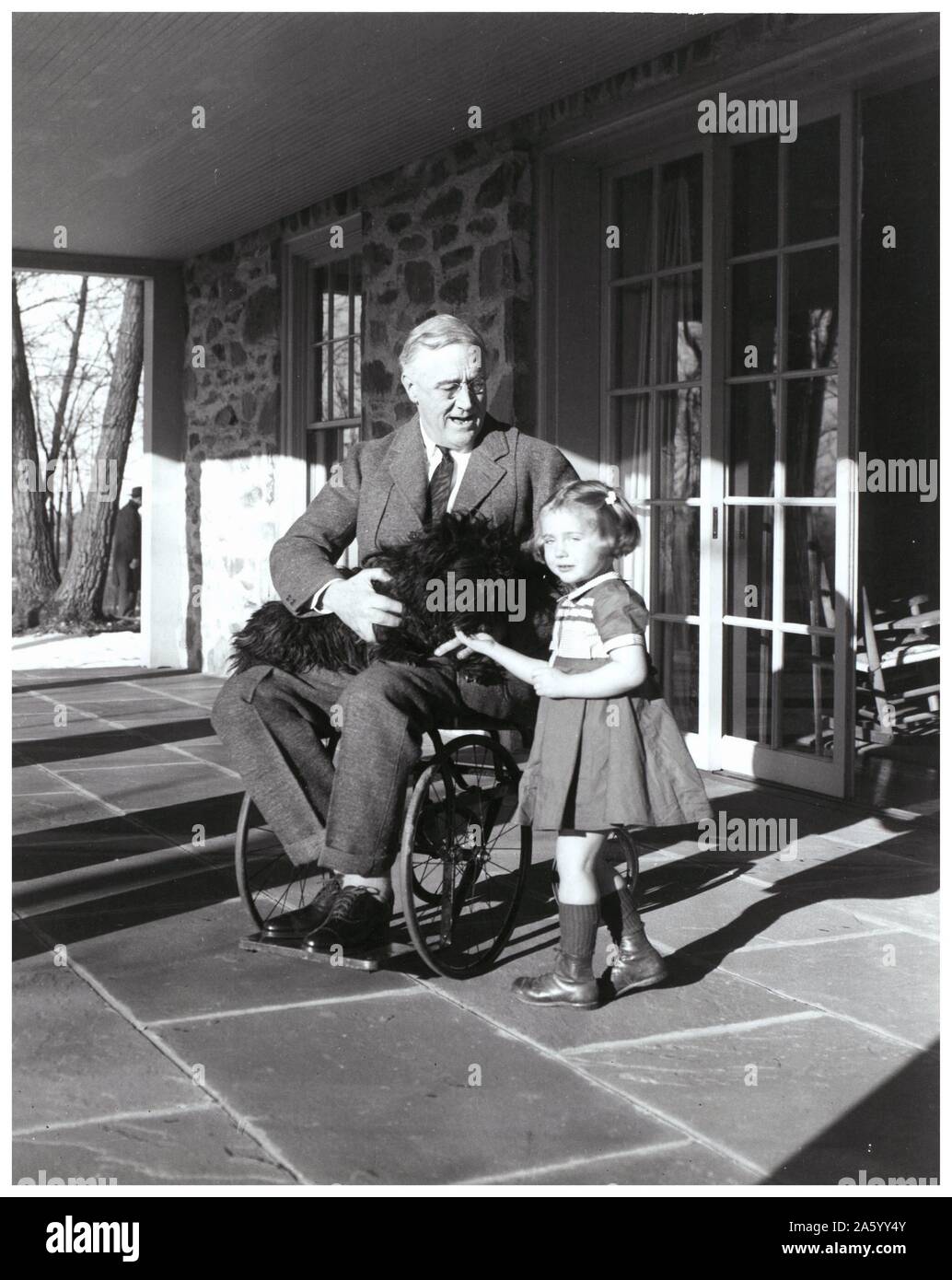 UNS Präsident Franklin d. Roosevelt seinen Hund als hält er sitzt auf einer Terrasse mit Ruthie Bie; Tochter eines Bediensteten 1938 Stockfoto