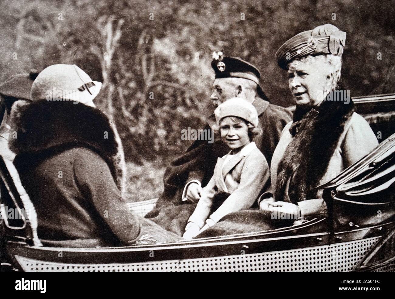 Foto von Prinzessin Elizabeth (1926-) bei ihren Großeltern, Queen Mary von Teck (1867-1953) und King George V (1865-1936). Auch abgebildet, ist ihre Mutter Lady Elizabeth (1900-2002). Vom 20. Jahrhundert Stockfoto