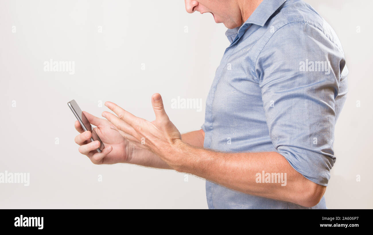 Unbekannter Mann mit seinem Smart phone Kreischen in der Frust über die schlechten Nachrichten.. Stockfoto