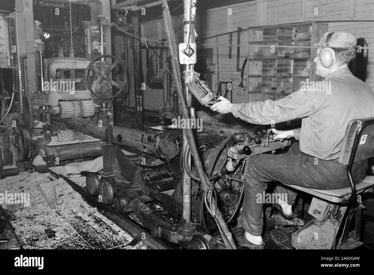 Mitarbeiter des Sägewerks beginnen mit dem zurechtschneiden, Insjön Schweden 1969. Mitarbeiter des Sägewerks sind das Schneiden der Protokolle in der richtigen Größe, Insjön Schweden 1969. Stockfoto