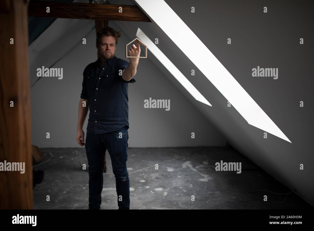 Architekt balancing Haus Modell auf seinen Finger, stehend auf der Baustelle Stockfoto