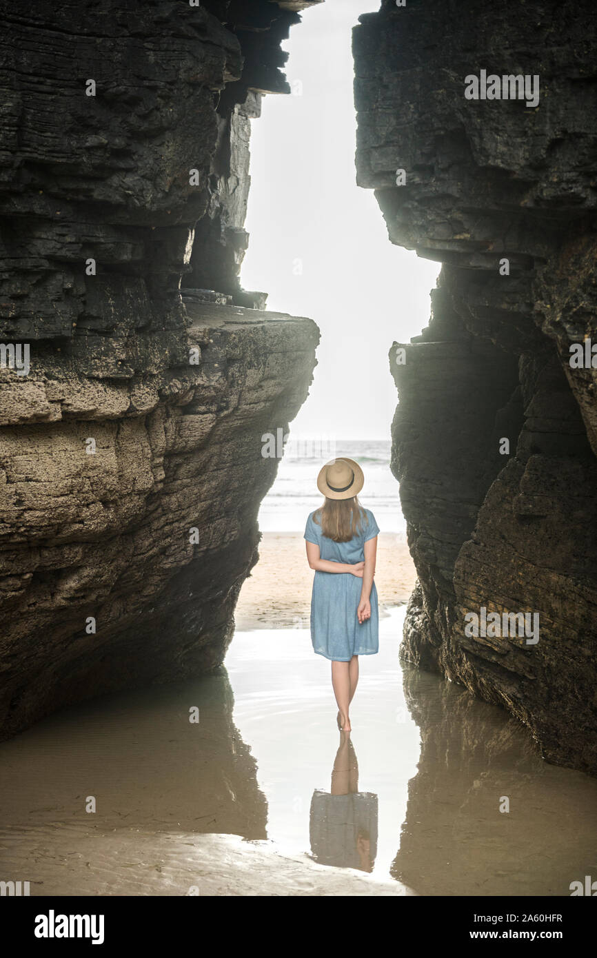 Frau stehend auf Kathedralen Strand mit Felsen, Rückansicht, Galizien, Spanien Stockfoto