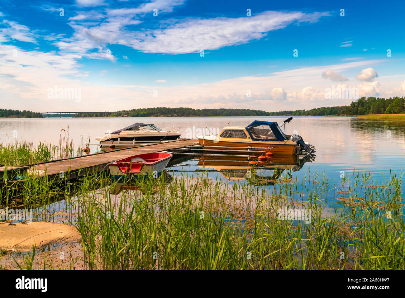 Boote im Fluss am Bootsanleger in Loftahammar, Schweden Stockfoto