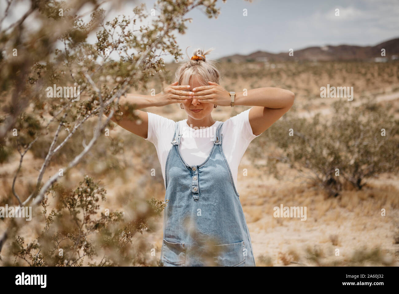 Junge Frau, die in der Wüste Landschaft, Joshua Tree National Park, Kalifornien, USA Stockfoto