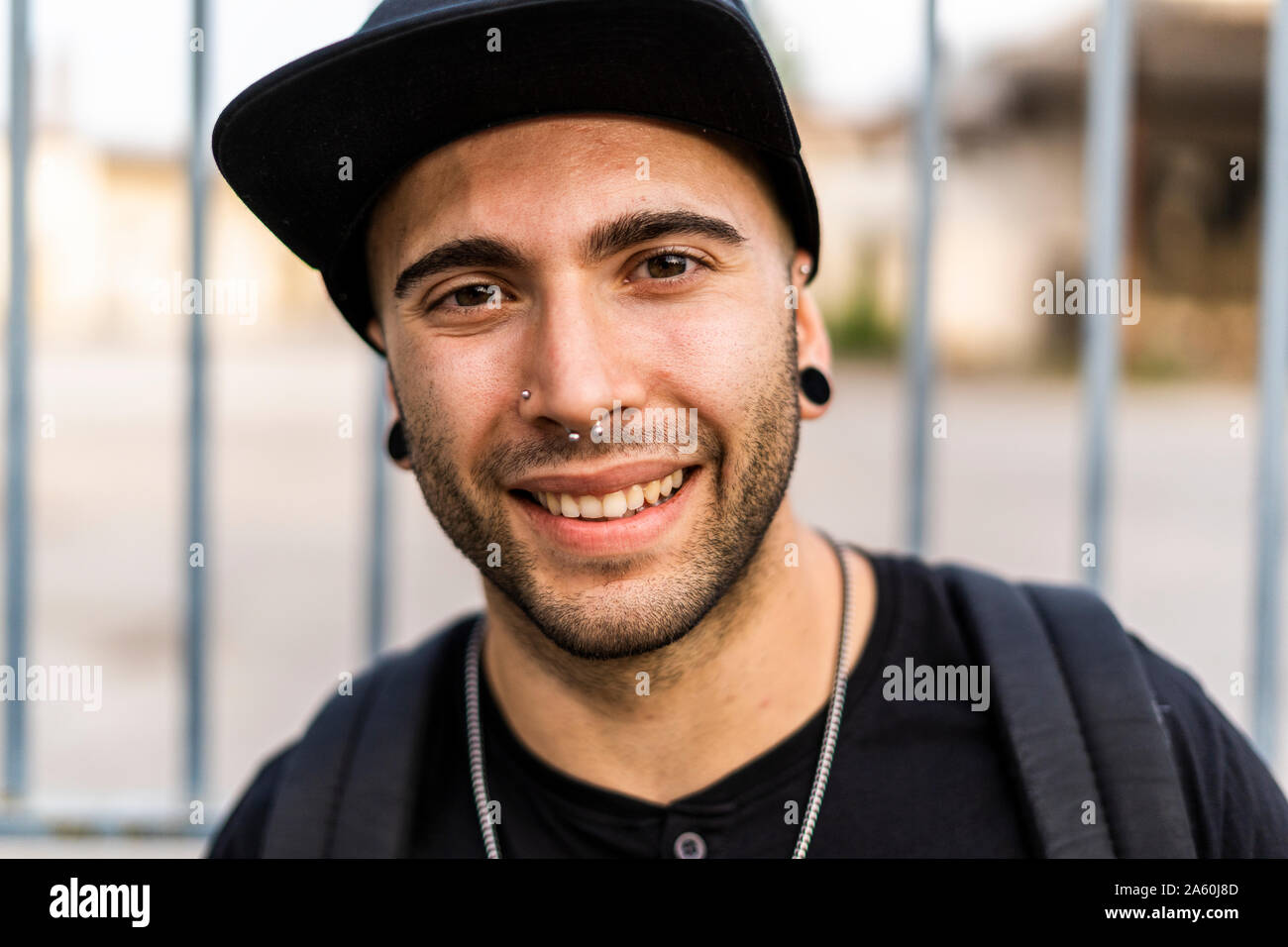 Porträt eines lächelnden jungen Mann mit Baseball Cap in der Stadt Stockfoto