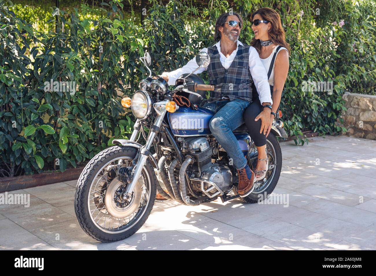 Glückliches junges Paar auf einem Oldtimer Motorrad Stockfoto