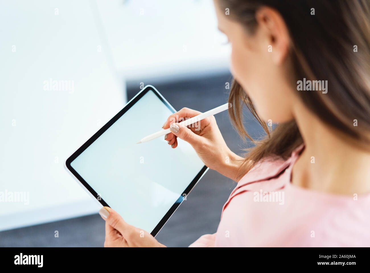 Blick über die Schulter der Frau Zeichnung mit Bleistift tablet Stockfoto