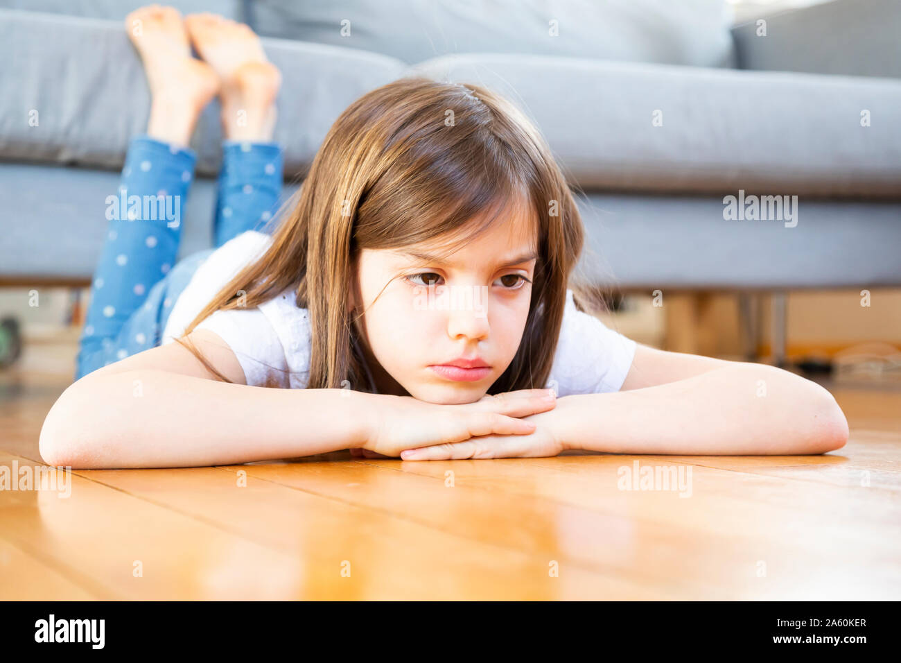 Portrait von sad Girl auf dem Boden liegend zu Hause Stockfoto