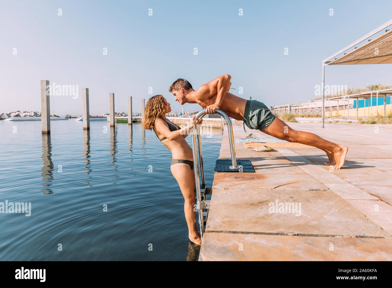 Junges Paar auf einem Pier am Meer Stockfoto