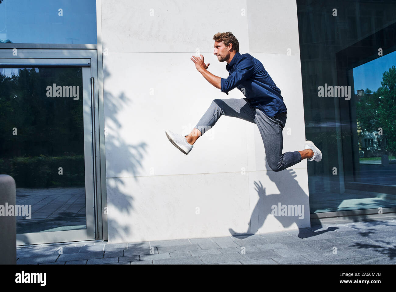 Junge Unternehmer springen mitten in der Luft in der Stadt Stockfoto