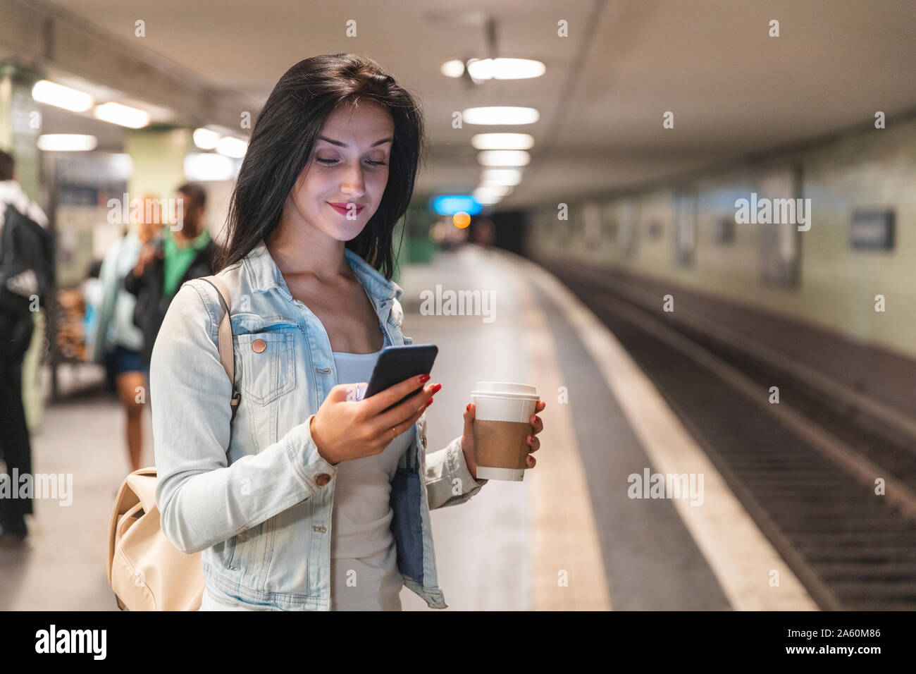 Junge Frau mit Handy in der U-Bahn Zug, Berlin, Deutschland Stockfoto