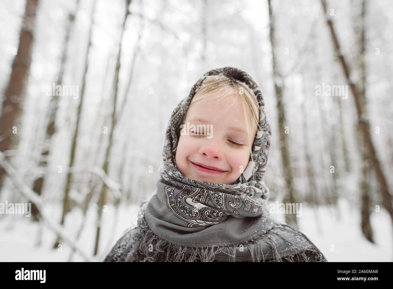 Portrait von glücklichen kleinen Mädchen mit Kopftuch im Winter Wald Stockfoto