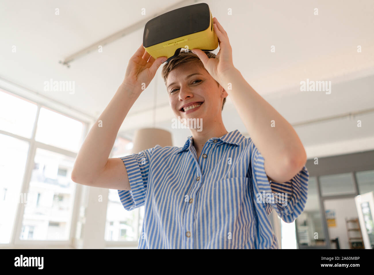 Portrait von lächelnden Geschäftsfrau mit VR-Brille im Büro Stockfoto