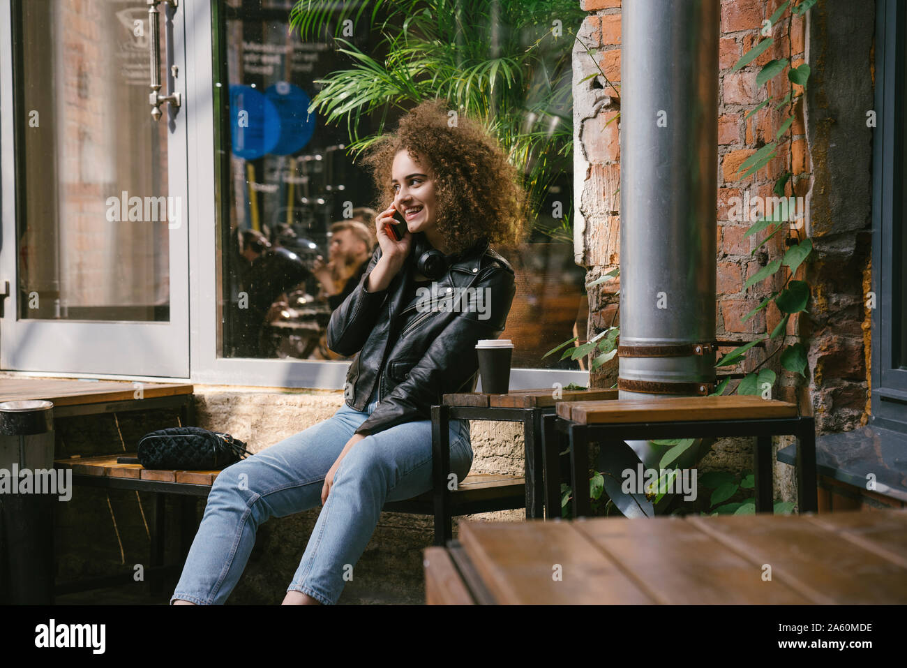Happy teenage Mädchen am Telefon Café im Freien sitzen und Kaffee trinken gehen Stockfoto