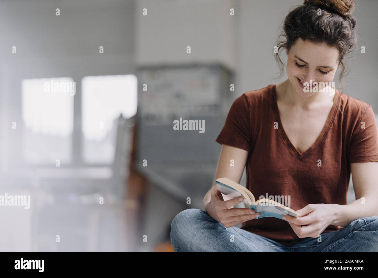 Lächelnde junge Frau, ein Buch zu lesen Stockfoto
