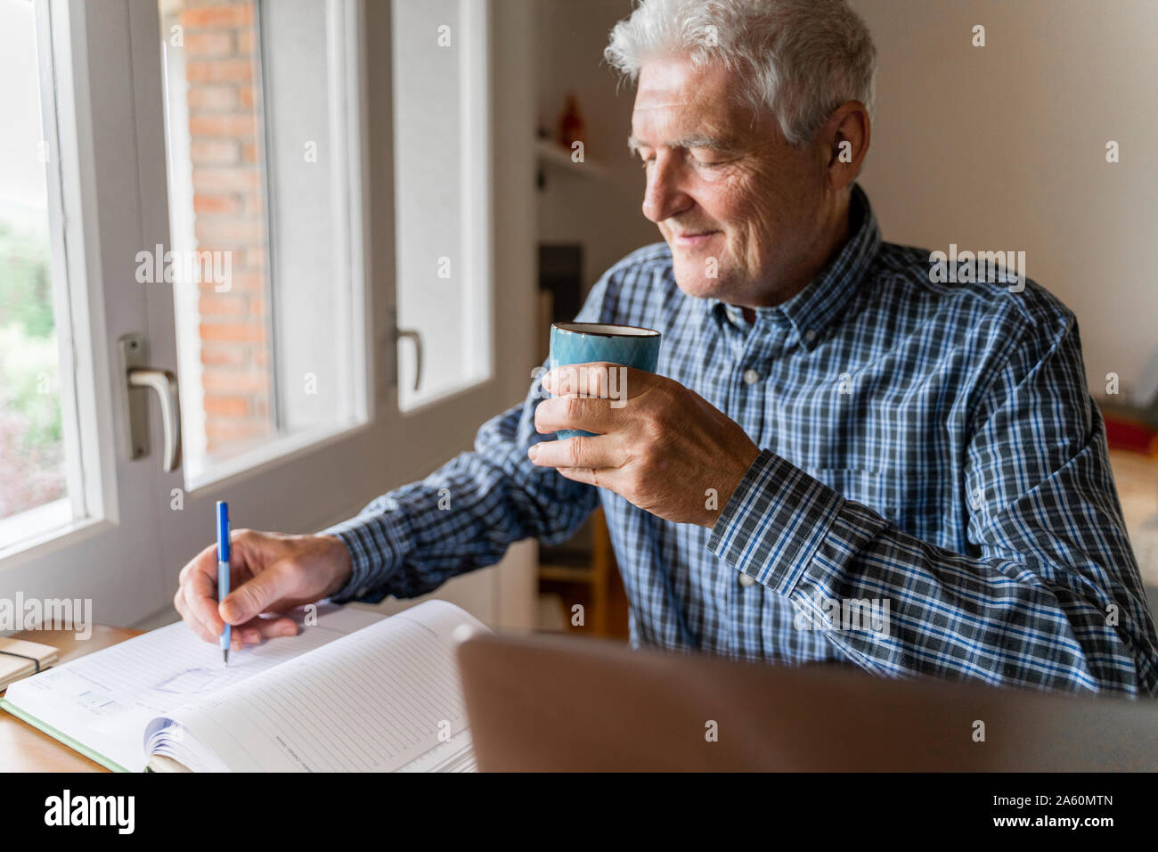 Ältere Menschen zu Hause vor laptop Notizen sitzen Stockfoto