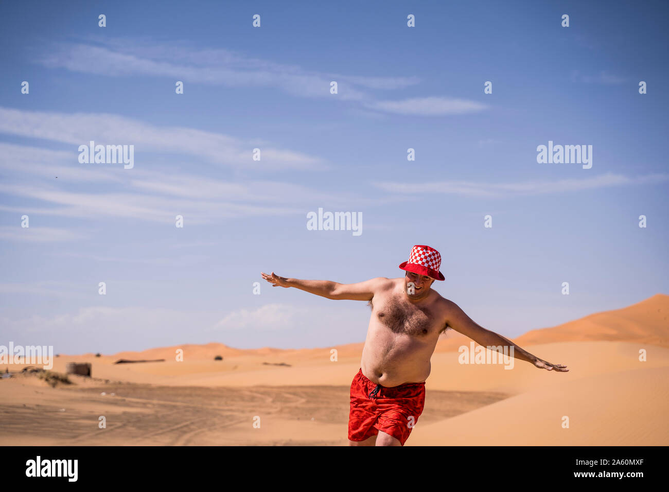 Happy übergewichtiger Mann mit Badeshorts in der Wüste von Marokko ausgeführt Stockfoto